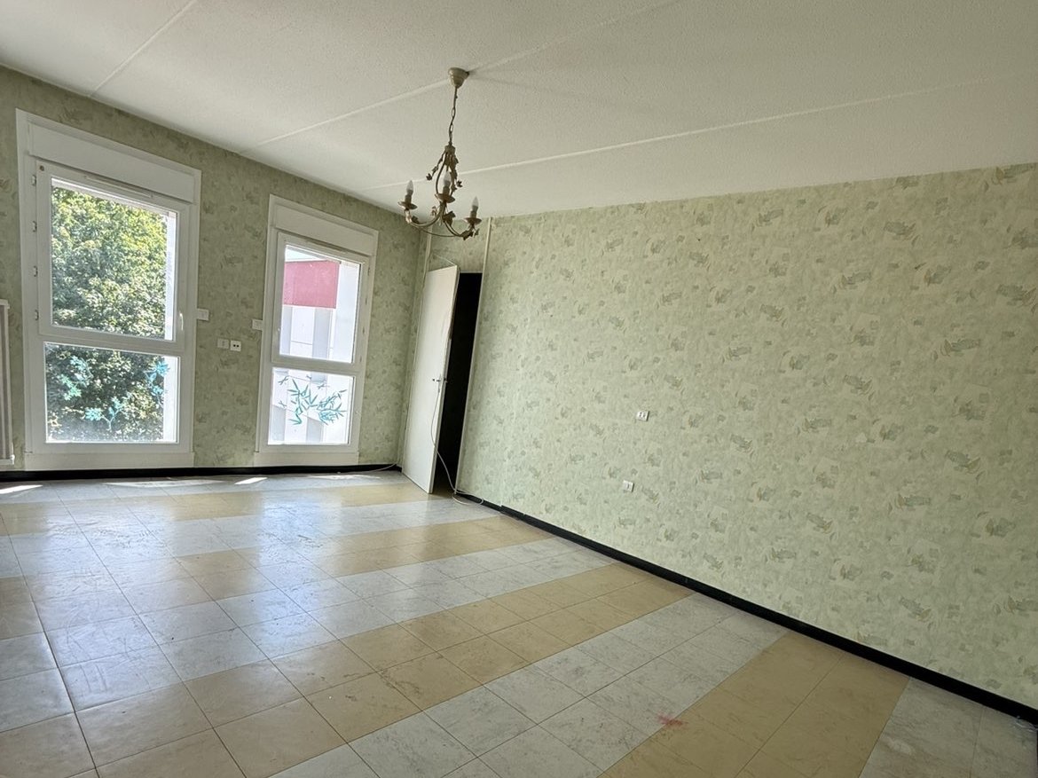 Appartement après déménagement — salon entièrement vidé
